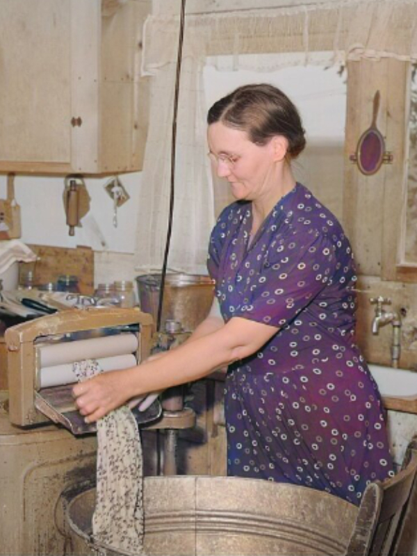 Photo of woman using wringer washing machine